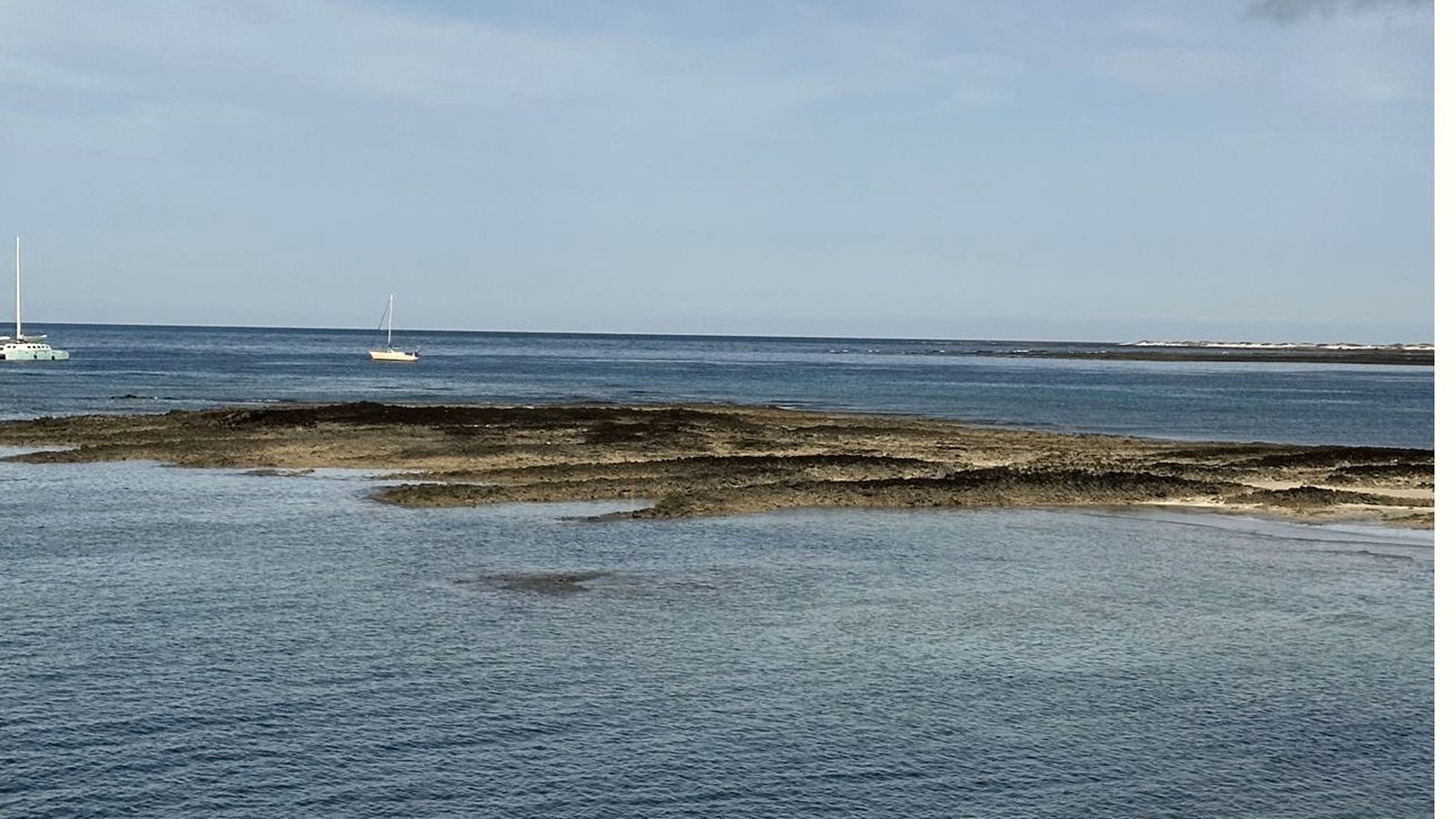 Mar de Fuerteventura con veleros fondeados junto a las rocas
